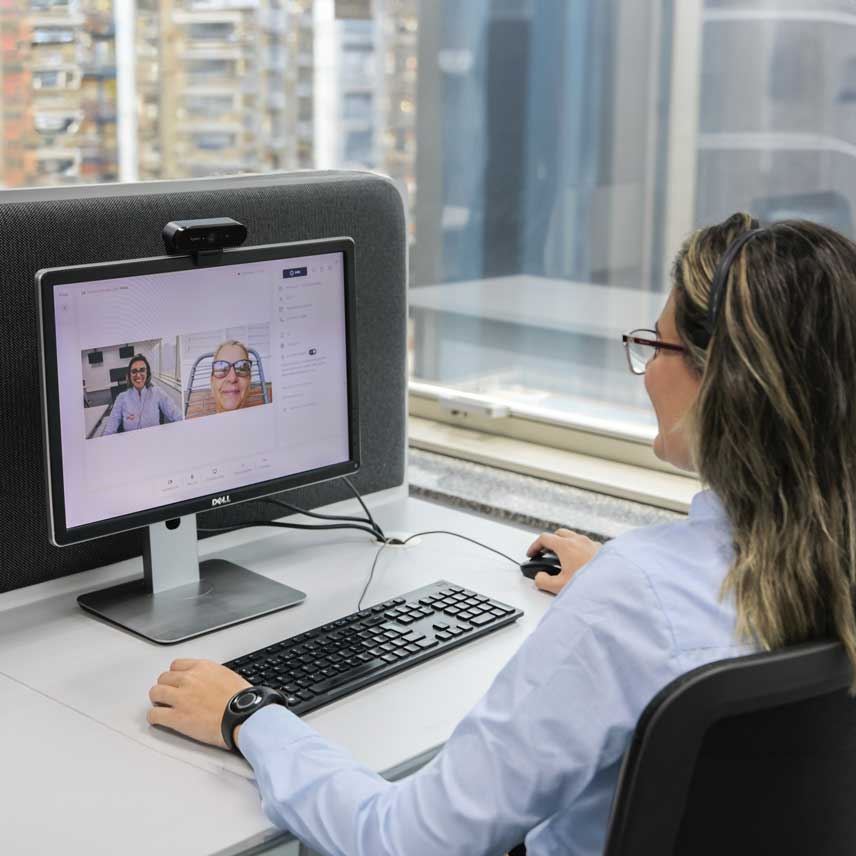 Imagem de uma senhora em uma chamada de vídeo com um doutor.